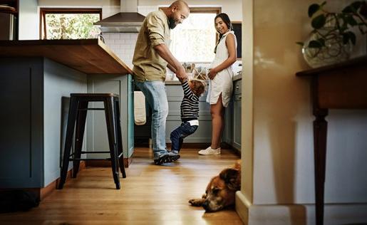 Family and dog roughhousing in kitchen