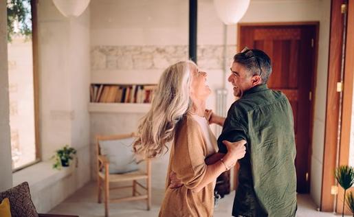 An older couple dancing in their home